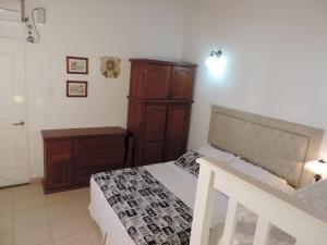 1 dormitorio con cama y tocador de madera en Hosteria Las Piedras en Puerto Madryn