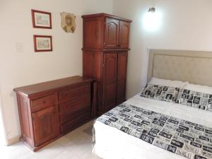 1 dormitorio con cama y tocador de madera en Hosteria Las Piedras en Puerto Madryn