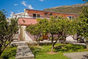 una casa rosa con árboles delante de ella en Apartments Stanka en Becici