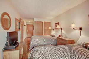 a hotel room with two beds and a tv at Fp202 Foxpine Inn Condo in Copper Mountain