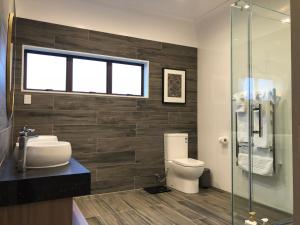 Un baño con inodoro y ducha de cristal. en Luxury K-Lodge with Golf course view-Rotorua, en Rotorua 35 fotos más