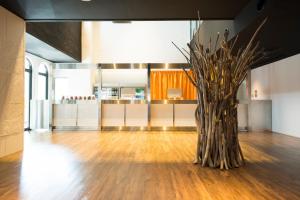 a tree in the middle of a room with a kitchen at EN HOTEL Fujisawa in Fujisawa