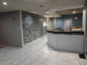 an office lobby with a counter and a brick wall at Travelodge by Wyndham Lincoln Northeast in Lincoln