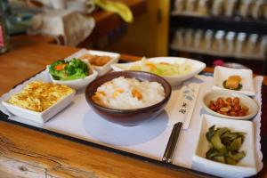 un vassoio di prodotti alimentari con riso e verdure su un tavolo di Country Grange B&B a Yuanshan