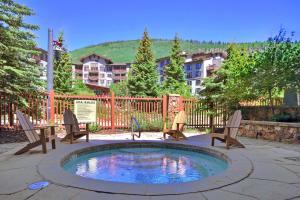 un patio con una piscina con sillas y una mesa en TX312 Taylors Crossing Condo, en Copper Mountain