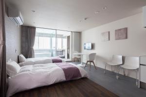 Schlafzimmer mit einem Bett, einem Tisch und Stühlen in der Unterkunft Private house Kuranoya Sapporo in Sapporo