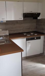 a kitchen with white cabinets and a stove top oven at Marina View in Bad Zwischenahn