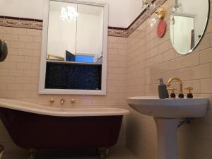 a bathroom with a tub and a sink and a mirror at Blackwood House in Healesville