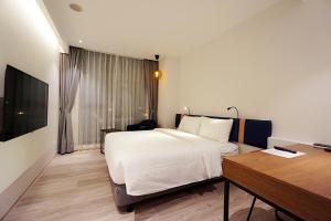 a hotel room with a bed and a desk and a desk at Explore Hotel in Taichung
