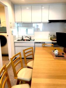 uma cozinha com uma mesa e cadeiras de madeira e uma cozinha em Tokyo Art House em Tóquio
