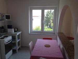 a small kitchen with a table and a window at Apartments Jelusic in Pinezici