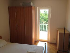 a bedroom with a bed and a sliding door at Apartments Jelusic in Pinezici