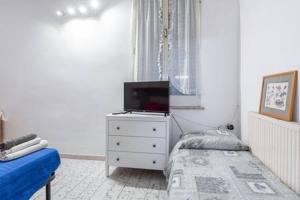 1 dormitorio con cama y vestidor con TV en casetta cassia roma, en Isola Farnese
