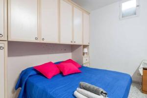 1 dormitorio con cama azul y almohadas rojas en casetta cassia roma, en Isola Farnese