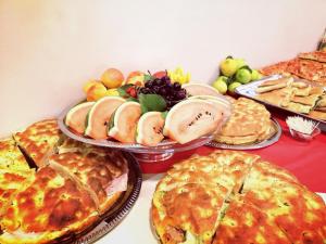 a table with pies and other food on it at Hotel San Martino in Cassibile