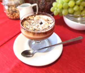 a cup of coffee on a plate with a spoon at Hotel San Martino in Cassibile