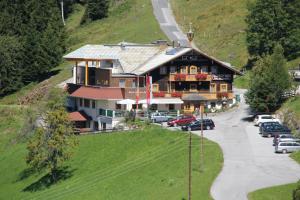 a large house on a hill with cars parked in front at Ferienanlage Reithof in Filzmoos