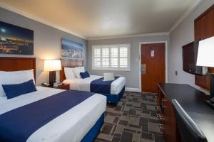 a hotel room with two beds and a flat screen tv at Bay Bridge Inn San Francisco in San Francisco