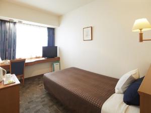 a hotel room with a bed and a desk at Hotel Roco Inn Okinawa in Naha