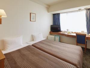 a hotel room with a large bed and a window at Hotel Roco Inn Okinawa in Naha
