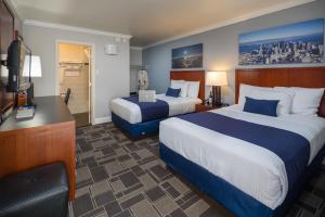 a hotel room with two beds and a desk at Bay Bridge Inn San Francisco in San Francisco