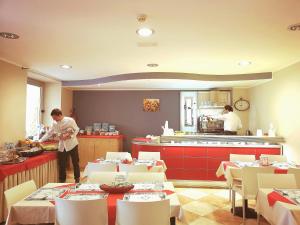 a restaurant with a chef preparing food in a kitchen at Hotel San Martino in Cassibile