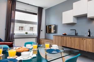 a kitchen and dining room with a glass table and blue chairs at Rooms and Apartments Glossy in Zagreb