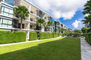 een park voor een gebouw met palmbomen bij The Title Comfort Condotel in Rawai Beach