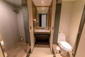 La salle de bains est pourvue de toilettes, d'un lavabo et d'un miroir. dans l'établissement Jeju Stay in Sungsan, à Seogwipo