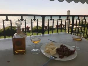 a table with a plate of food and two glasses of wine at Iris Seafront Apartments in Fourka