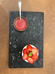 a plate with a bowl of strawberries and a sauce at La Tenuta di Trimalcione in Pofi