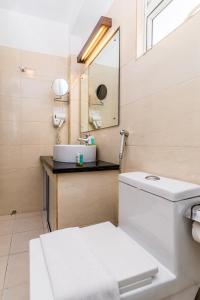 a bathroom with a toilet, sink and mirror at Ceylon City Hotel,Colombo in Colombo