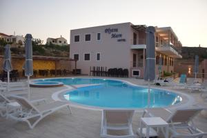 ein Schwimmbad mit Liegestühlen und ein Hotel in der Unterkunft Plytra Mare Hotel in Plitra
