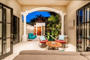 a living room with a couch and chairs and a pool at Villa Kapai in Seminyak