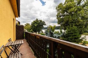 a balcony with a bench and a view of a river at Apartmány Jedovnice in Jedovnice