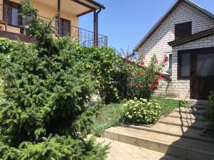 een tuin voor een huis met bloemen bij Гостевой дом in Sennoy