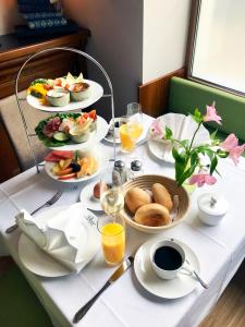 a table with plates of food and glasses of orange juice at MOMENTS Boutique Hotel in Bautzen