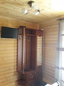 einem Holzschrank mit einem TV an der Wand in der Unterkunft Anastasiya in Izky