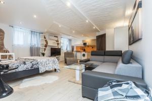 a living room with a couch and a bed at Trys Apartamentai in Palanga