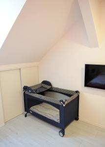 ein kleines Bett in einem Zimmer mit einem TV in der Unterkunft Apartment Vatra in Sarajevo