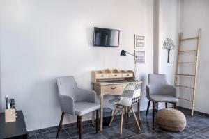 a room with three chairs and a desk with a tv at Yasemi Studio 1 in Heraklio