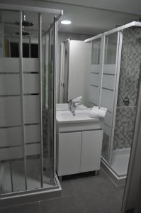 un bagno con lavandino e doccia di Corujinha Hostel a Lisbona