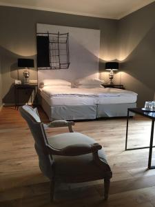 a bedroom with a bed and a chair and lamps at Strandhotel Margaretha in St. Wolfgang
