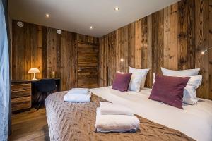 1 dormitorio con 1 cama grande y 2 almohadas en Moulin Chalets Les Gets - by EMERALD STAY en Les Gets