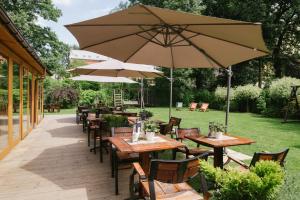 an outdoor patio with tables and chairs with umbrellas at Zulian Aparthotel by Artery Hotels in Kraków