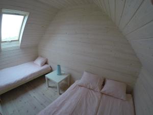 um pequeno quarto com duas camas e uma mesa em Domki u Leona em Dąbki