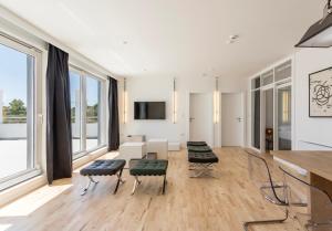 a living room with a table and chairs and windows at Villa Mila Kastela in Kastel Novi