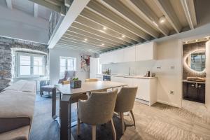 a kitchen and living room with a table and chairs at Alma Lofts in Zadar