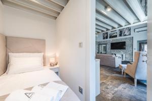 um quarto com uma cama e uma sala de estar em Alma Lofts em Zadar