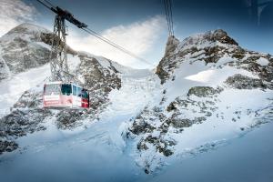 a ski lift going up a snow covered mountain at B-Inn Apartments Zermatt in Zermatt